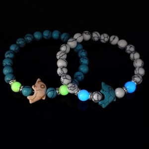 Luminous turquoise beaded bracelets with dolphin pendants in blue and white marble style