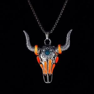 Detailed macro view of vintage bull skull pendant with turquoise stone and orange inlay