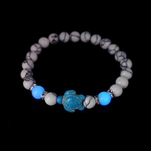Luminous turquoise turtle bracelet with white textured beads and silver spacers