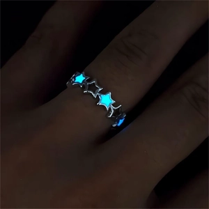 Luminous silver hollow star ring with blue glow effect worn on finger in dark