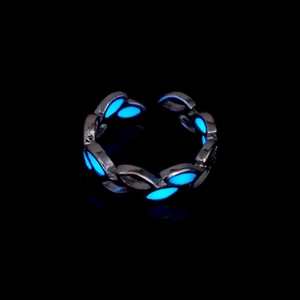 Macro shot of luminous blue leaf ring with adjustable silver branch design for Halloween