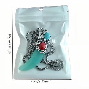 Dettaglio della collana dente di lupo luminoso con pietra turchese e pendente in metallo