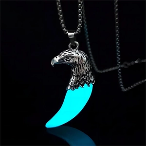Dettaglio del ciondolo testa di aquila con effetto luminoso blu al buio profondo