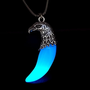 Dettaglio del ciondolo vintage testa d'aquila con dente di lupo blu fluorescente
