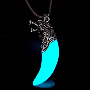 Glow-in-the-dark wolf tooth pendant with blue luminous effect and detailed silver wolf head