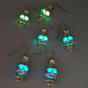 Detailansicht leuchtender Totenkopf-Ohrringe in Grün, Cyan und Blau für Halloween-Nächte