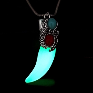 Dettaglio della collana a dente di lupo con bagliore blu fluorescente e incisioni fini