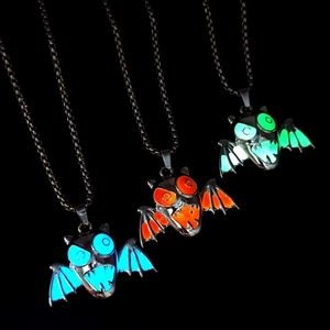 Glow-in-the-dark Halloween bat wing necklaces in blue, orange, and green light