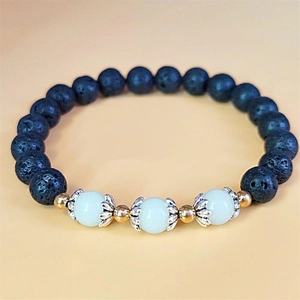 Macro detail of dark lava stone beads and luminous stones on a vintage lotus bracelet