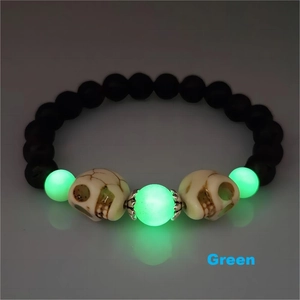 Gros plan du bracelet tête de mort Halloween avec perles vertes lumineuses et noires