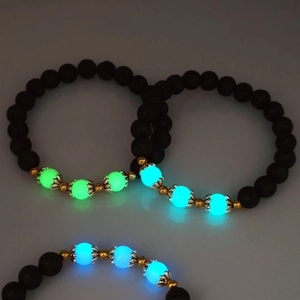 Detail view of luminous beads with lotus petal caps and black lava stone on bracelets