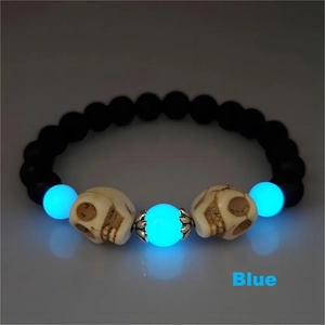 Bracelet d'Halloween lumineux avec perles de crâne et pierres de lave bleues sur fond noir