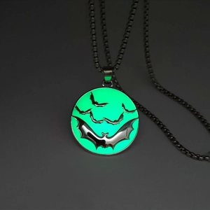 Vue détaillée du pendentif chauve-souris Halloween avec effet lumineux vert dans l'obscurité