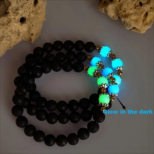 Luminous lotus flower charm bracelet with dark volcanic lava stone beads and glowing accents