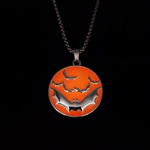 Détail d'un collier de chauve-souris d'Halloween avec des chauves-souris noires sur pendentif orange