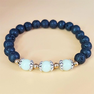 Detailed macro view of black volcanic lava stone beads with luminous center gems and lotus spacers