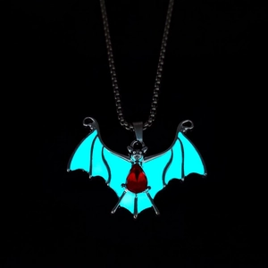 Detailaufnahme von Fledermaus-Anhänger mit leuchtend blauen Flügeln und rotem Edelstein