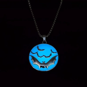 Détail macro du collier pendentif chauve-souris montrant l'effet bleu lumineux dans le noir