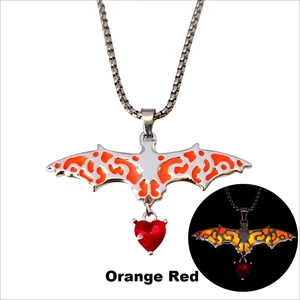Gothic luminous bat necklace featuring red heart glass gemstone and orange wing details