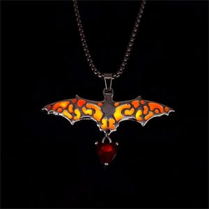 Gothic bat wing necklace with heart-shaped red gemstone detail on black background