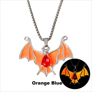 Makro-Detail des Fledermaus-Anhängers mit orangefarbenem Leuchteffekt und rotem Stein