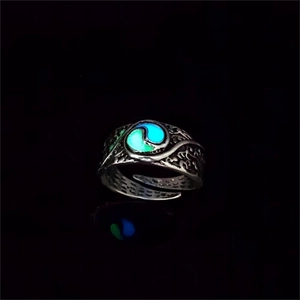 Macro shot of glow-in-the-dark Tai Chi ring with vintage embossed patterns in dark background