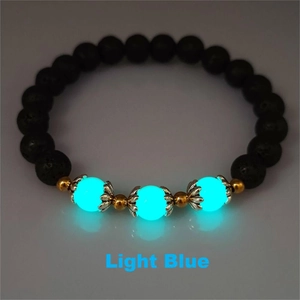 Macro detail of elastic bracelet with black lava stone beads and light blue luminous accents