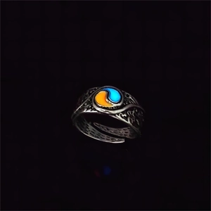 Close-up of retro glowing ring with embossed swirl patterns and luminous dual-tone inlay
