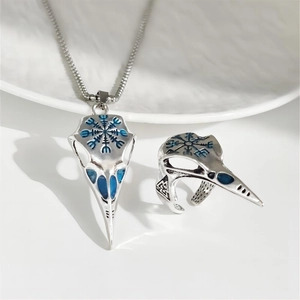 Macro shot of Viking bird skull pendant and ring set with glowing blue compass detail