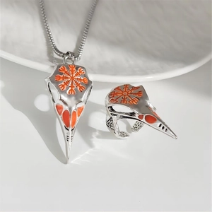 Detail of Viking crow skull pendant and ring set featuring orange Vegvisir rune pattern