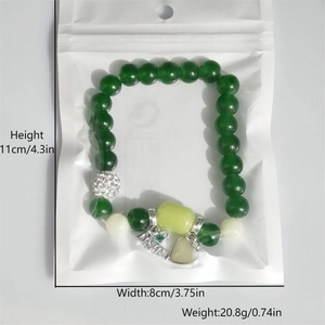 Detailed view of luminous green bead bracelet with Mom charm in a poly bag packaging