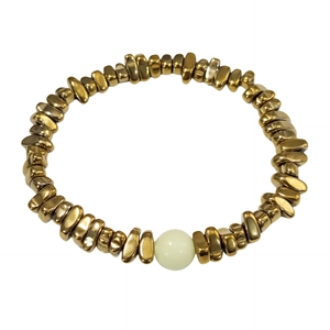 Vue détaillée des perles métalliques dorées irrégulières et d'une perle lumineuse du bracelet