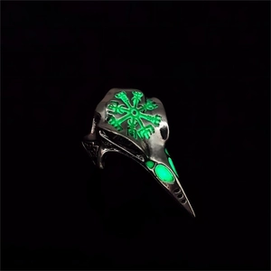 Macro-opname van Viking raven schedel ring met lichtgevend groen Vegvisir kompas symbool