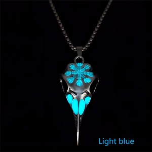 Macro detail of bird skull pendant with blue luminous rune and silver metal finish