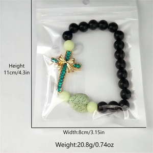 Bracelet croix lumineux avec pierre cœur verte et détail nœud, dimensions incluses