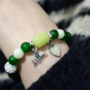 Detail shot of multicolor beaded bracelet featuring a silver MOM charm with a blue diamond