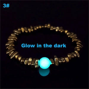 Détail de perles dorées irrégulières et bracelet avec perle cyan lumineuse dans le noir