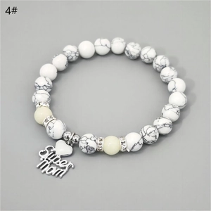 Detailed macro view of white turquoise beads and Super Mom engraved heart charm