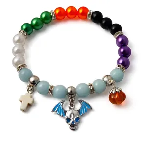Luminous Day of the Dead beaded bracelet with skull and pumpkin charms on white background