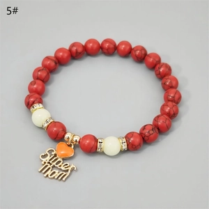 Detailed close-up of Super Mom heart charm and red turquoise beads on luminous bracelet