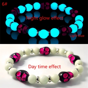 Luminous skull beaded bracelet showing blue night glow and daytime appearance