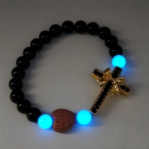 Vue détaillée du bracelet croix lumineuse avec perles noires et pierre de lave en cœur