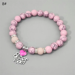 Detail of the Super Mom heart charm and pink marble beaded bracelet for Mother's Day