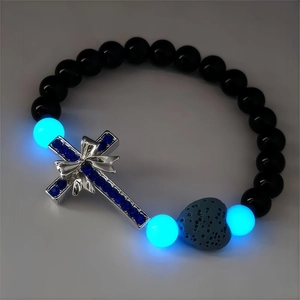 Vue macro de perles lumineuses avec croix en métal et pierre de lave en forme de cœur