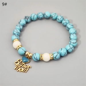 Detailed view of Super Mom heart pendant and turquoise beaded bracelet with crystals
