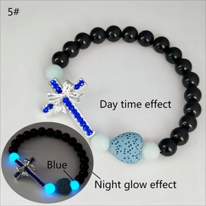 Détail des perles lumineuses et pendentif croix en argent avec pierre de lave bleue