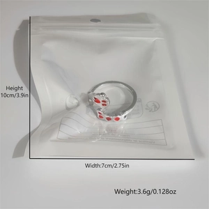 Detail view of silver glow-in-the-dark ring with red footprints in clear packaging