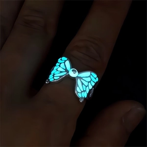 Luminous butterfly ring in silver with blue glow-in-the-dark wings on hand