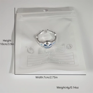 Macro shot of silver hip-hop skull ring with blue glow finish in packaging