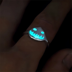 Close-up of glowing jack-o-lantern face ring in dark environment for Halloween